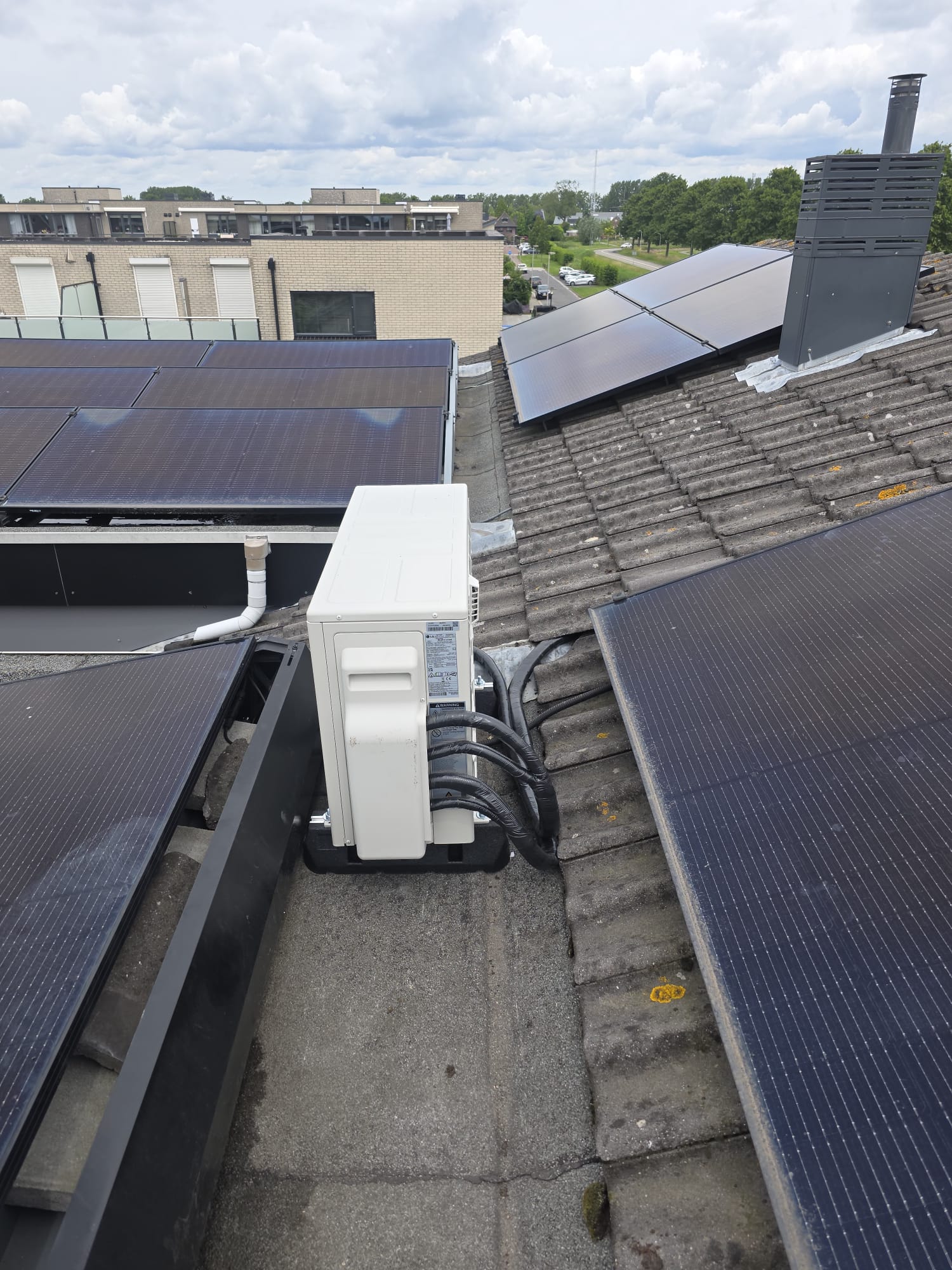 LG buitenunit — Dakopstelling tussen zonnepanelen